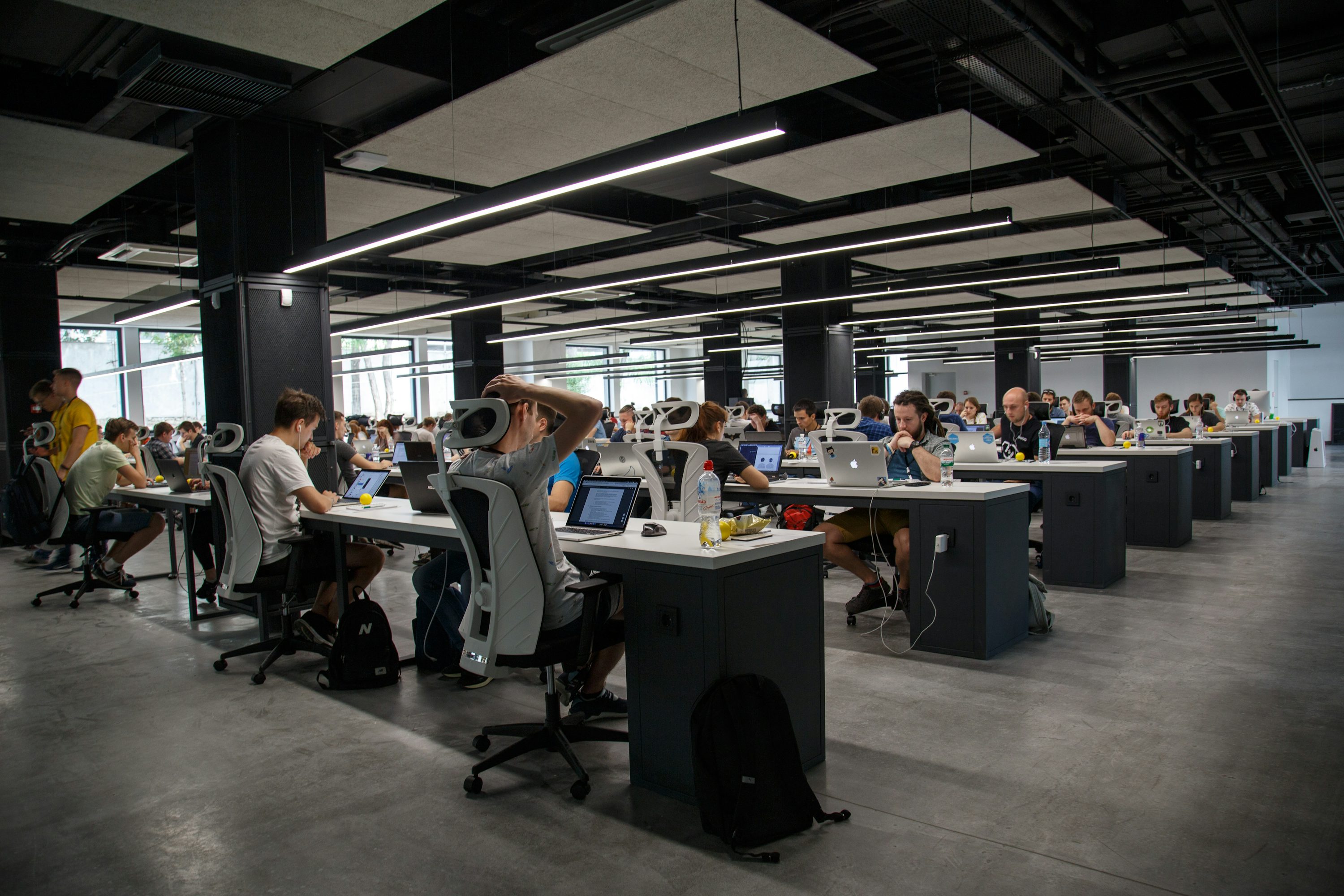 Des développeurs travaillent à leurs bureaux dans un grand espace ouvert.